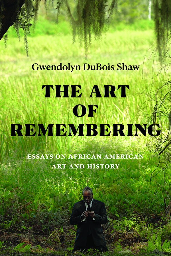 Cover of The Art of Remembering: Essays on African American Art and History by Gwendolyn DuBois Shaw. Cover features a photograph of an African American man kneeling in a suit in the foreground. The man kneels in a field of tall, green grass with whispy vines hanging above his head. The field extends far into the background, revealing a large grassy plain. 